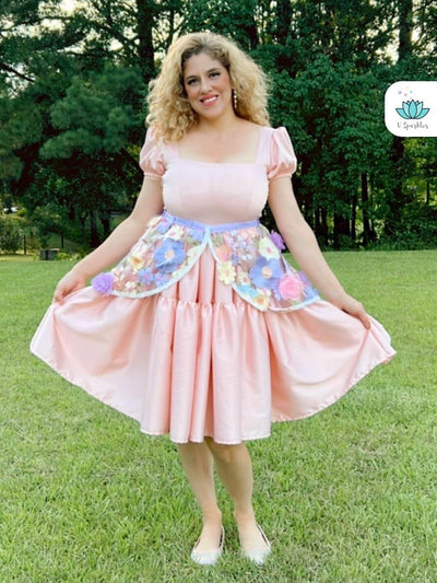 Floral Fairytale Dress-Up Overskirt for Women – Easy Rapunzel Costume Transformation – This floral dress-up overskirt offers an easy and magical transformation into Rapunzel for adults attending Halloween or Disneybounding events. Available in mid-size and plus-size options.